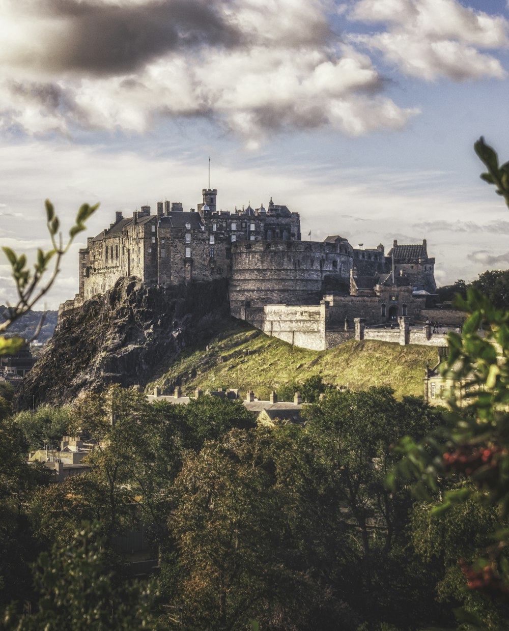 a castle on top of a hill surrounded by trees