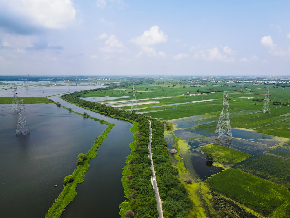 a large body of water surrounded by lush green fields