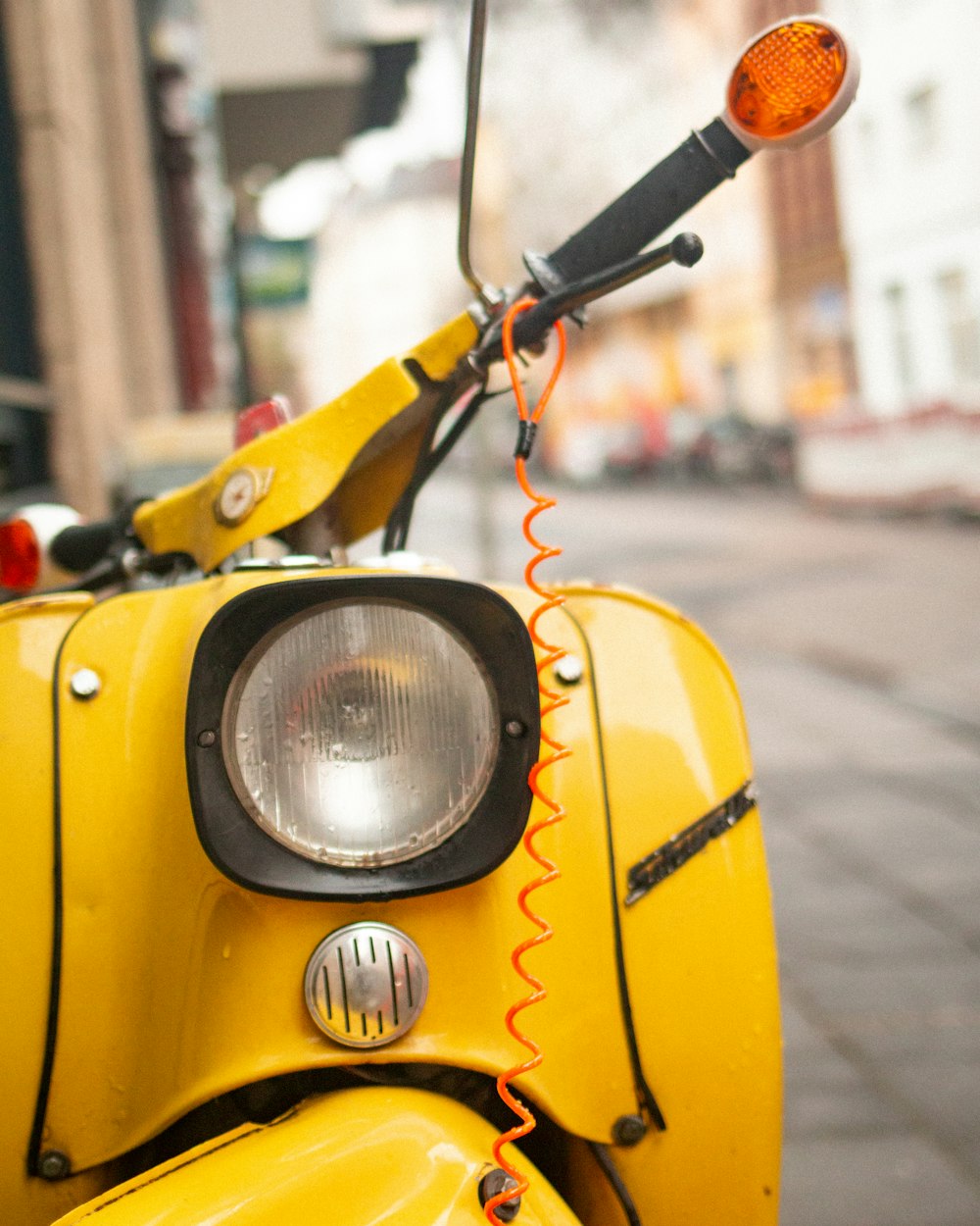 a yellow scooter parked on the side of the road