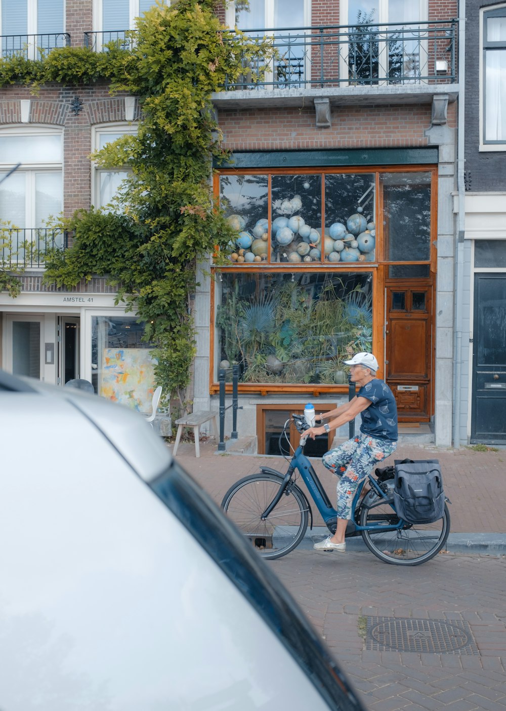 a man riding a bike down a street next to a building