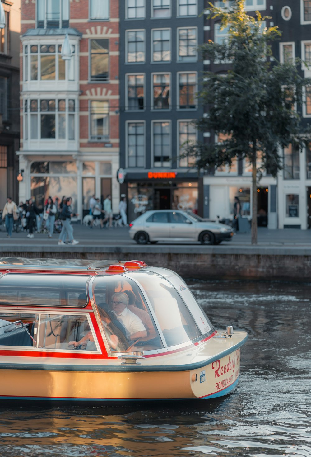 a small boat floating down a river next to tall buildings