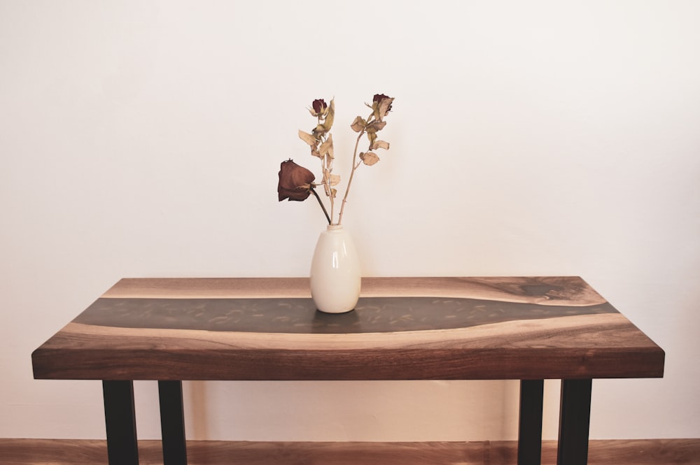 a wooden table with a vase of flowers on top of it