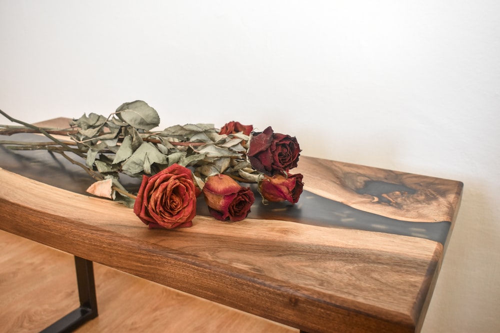 a bunch of roses sitting on top of a wooden table