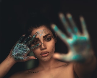 a woman with her hands painted blue and green