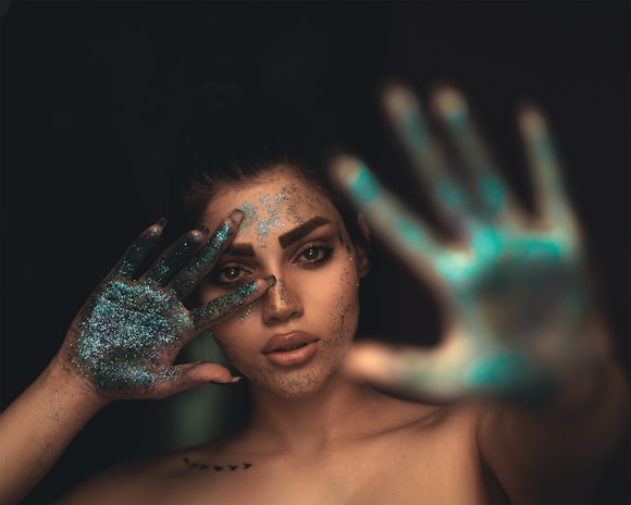 a woman with her hands painted blue and green