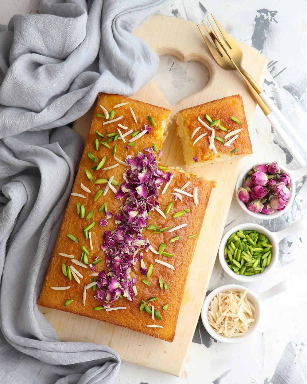 a wooden cutting board topped with a loaf of cake