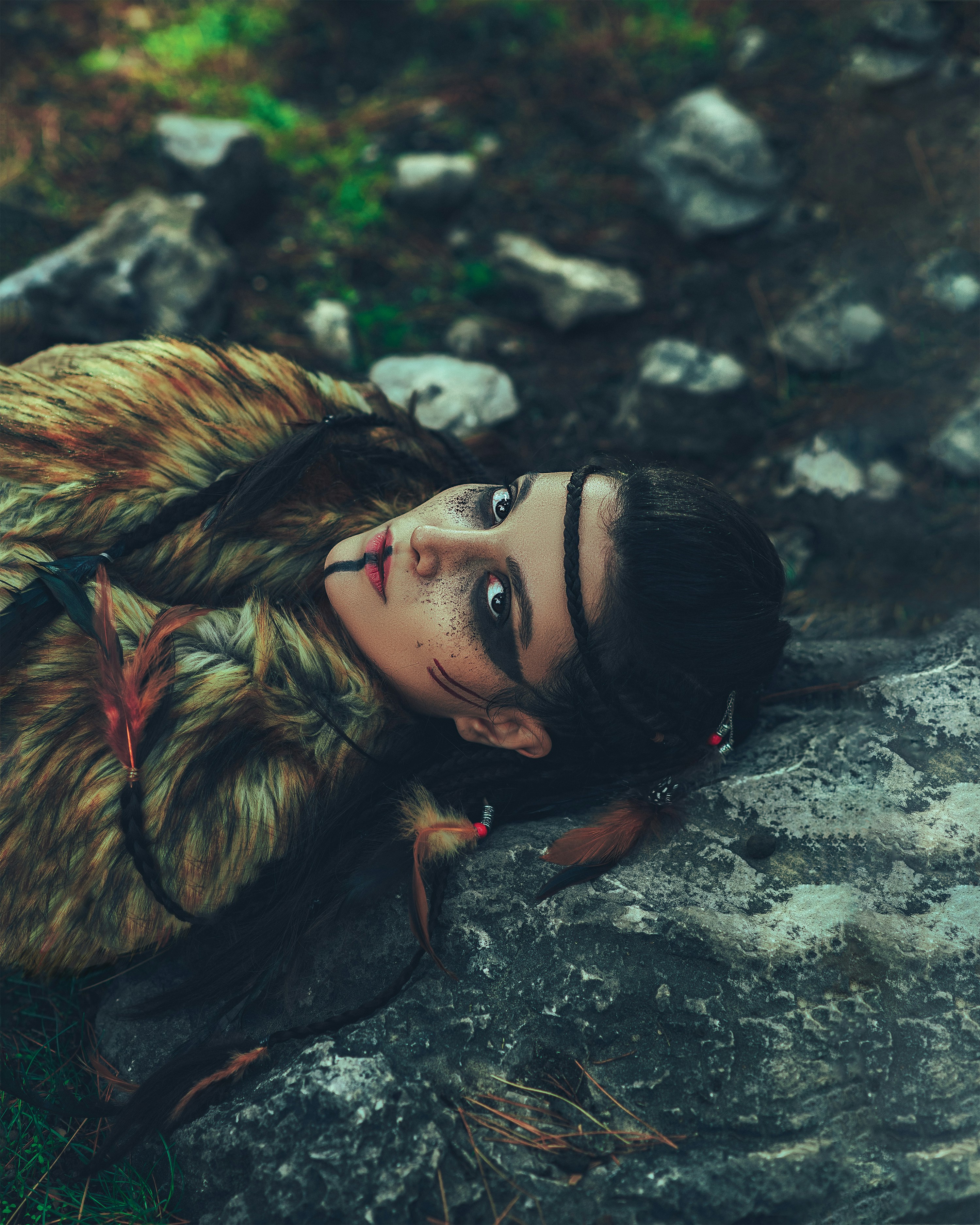A woman laying on top of a rock next to a forest photo – Free Woman ...