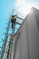 a man on a scaffold working on the side of a building