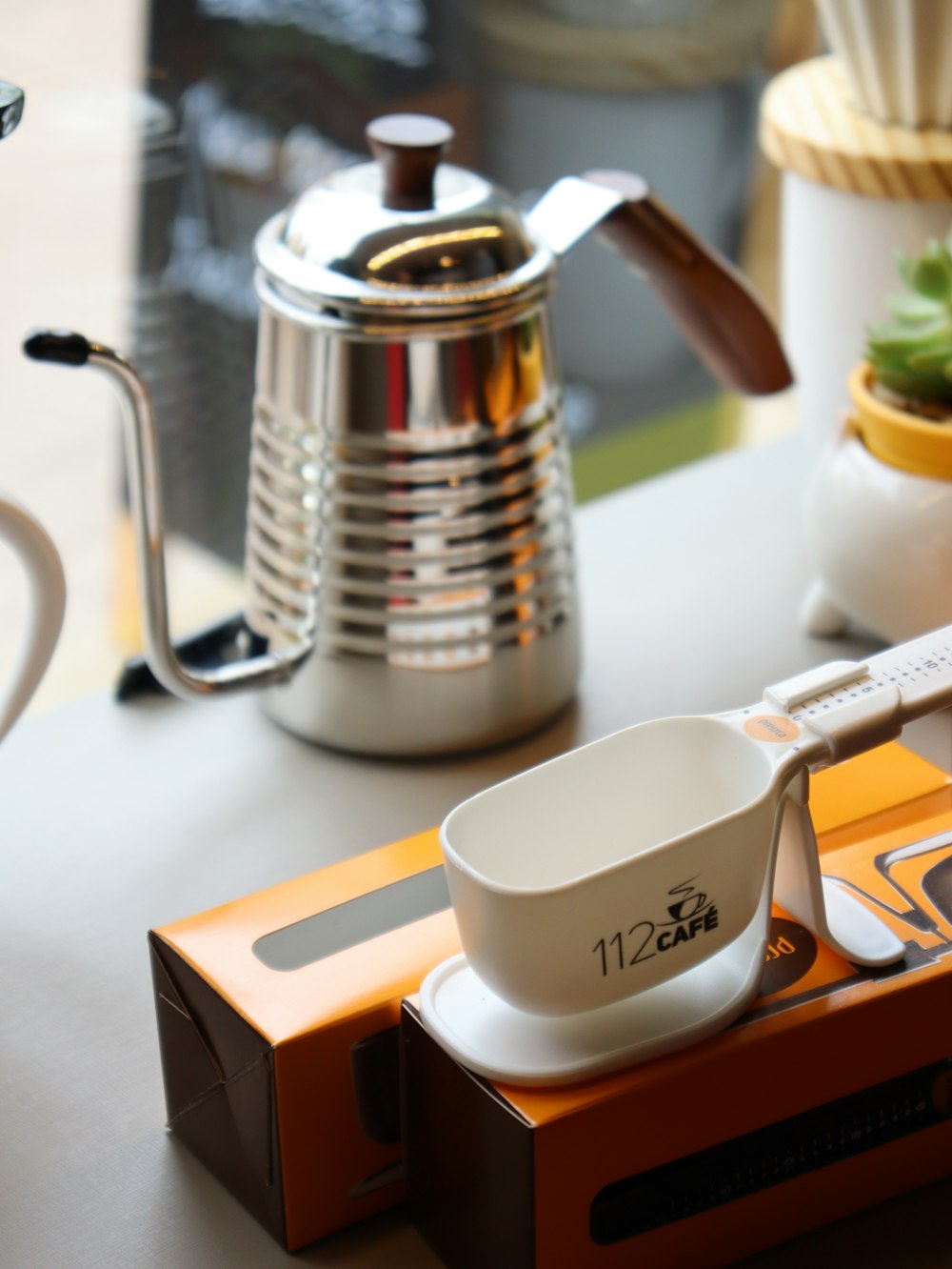 a coffee pot and a measuring cup on a table