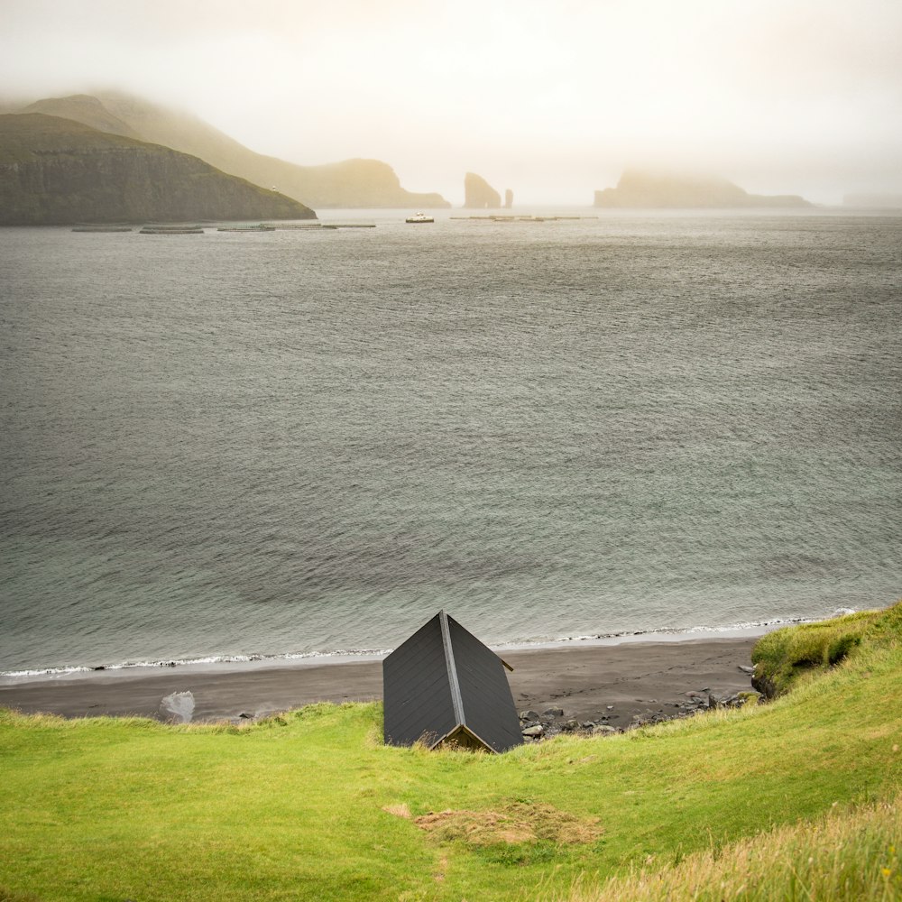 a black structure sitting on top of a lush green field