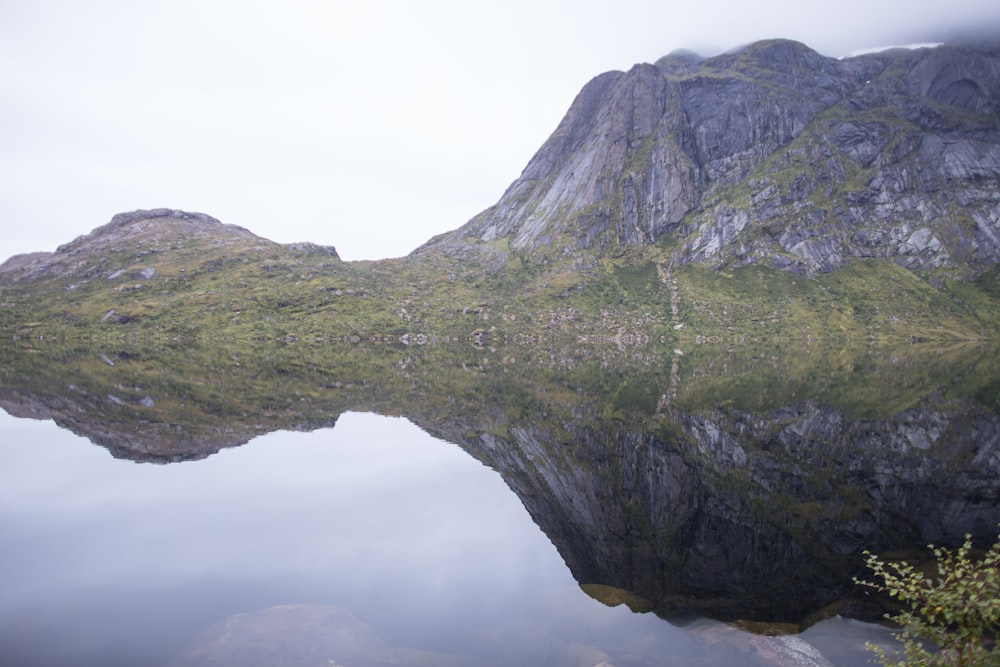 a mountain is reflected in the still water of a lake