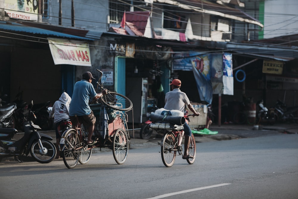 a couple of people riding bikes down a street