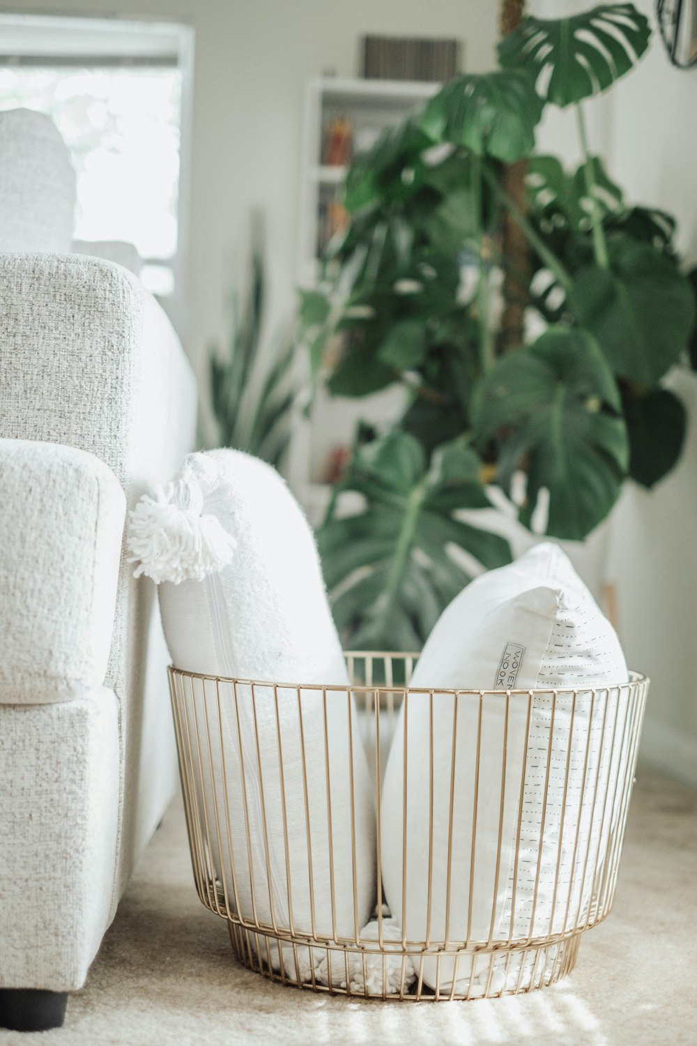 uma cadeira branca e uma cesta no chão