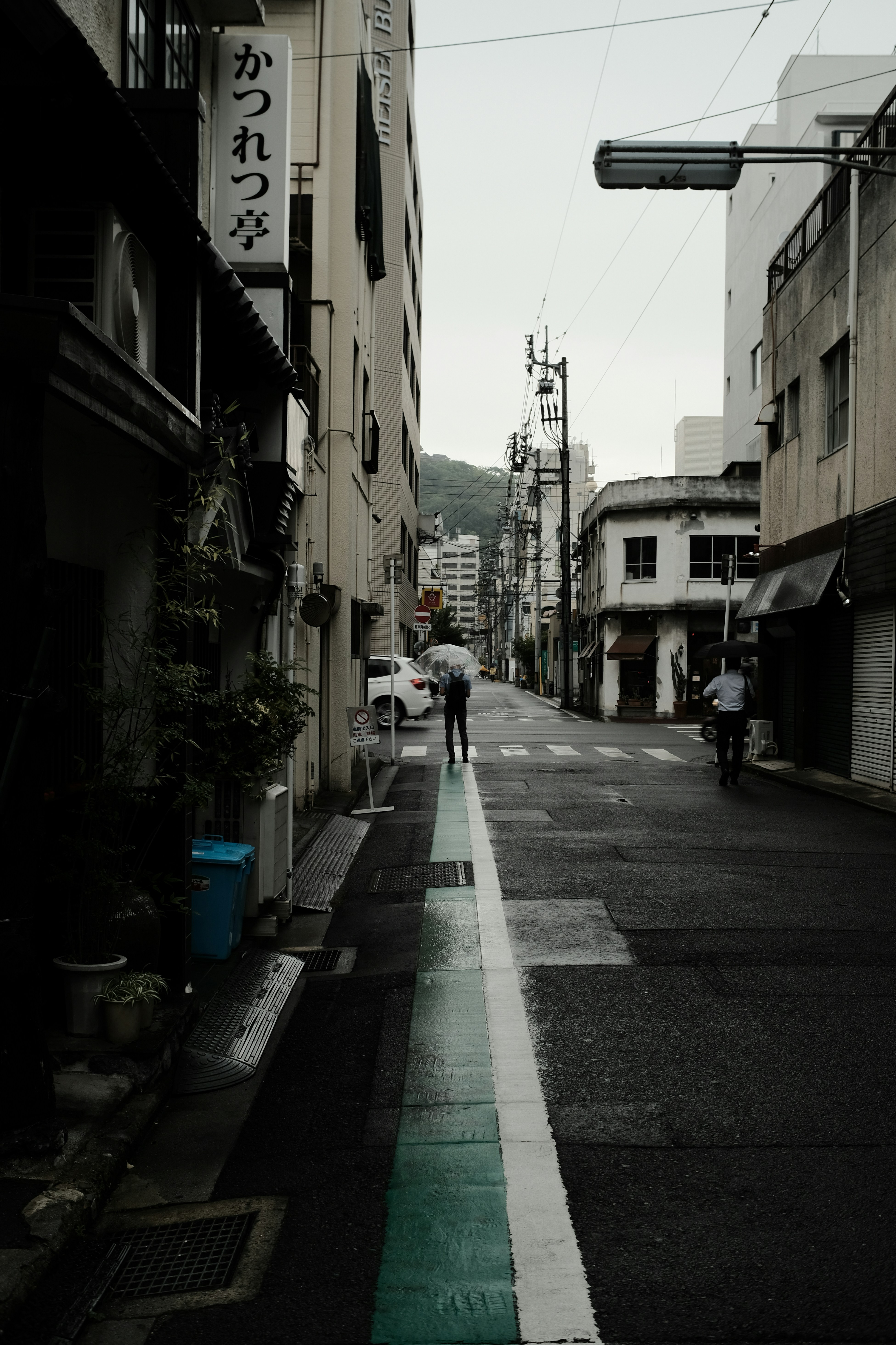 a man walking down a street next to tall buildings