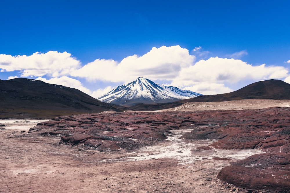 a dirt field with a mountain in the background