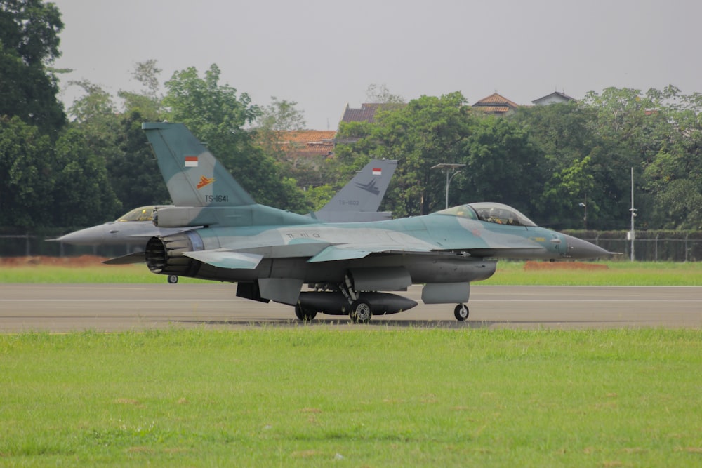 a fighter jet sitting on top of an airport runway