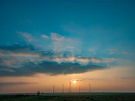 A wind turbine farm at sunset, highlighting clean energy infrastructure.