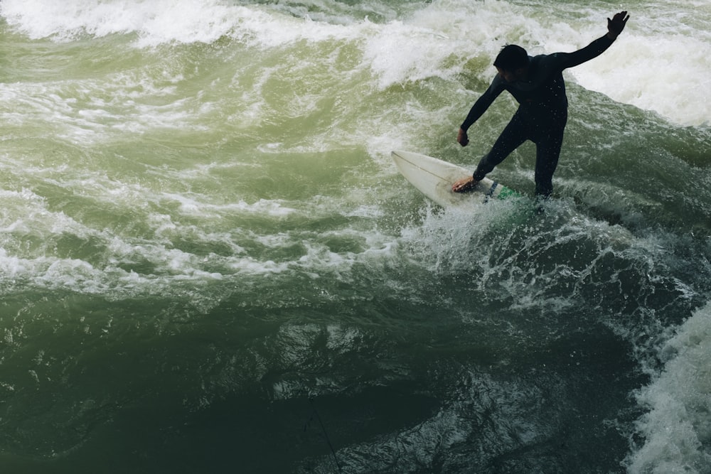 a man riding a wave on top of a surfboard