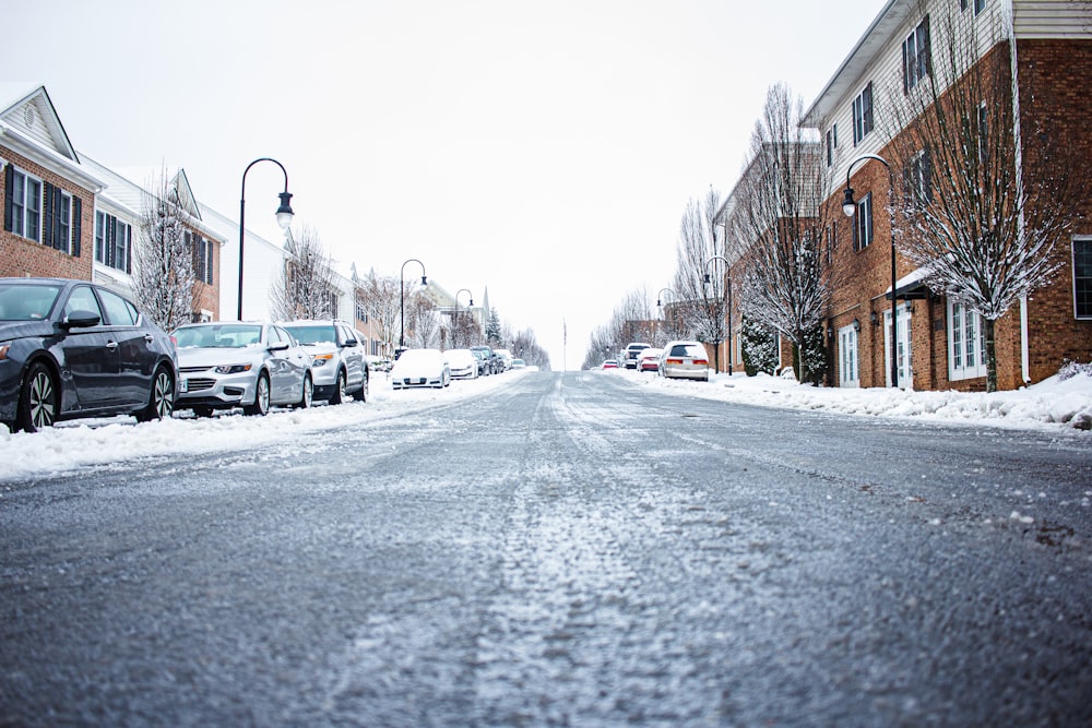 Eine verschneite Straße mit Autos, die an der Seite geparkt sind