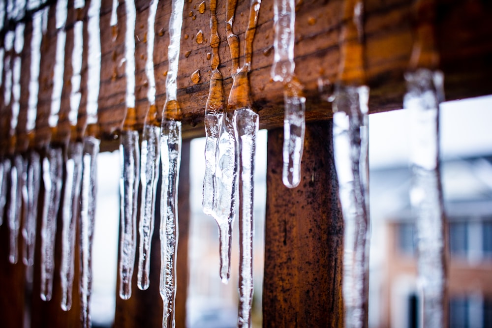 icicles are hanging from a wooden slatted window