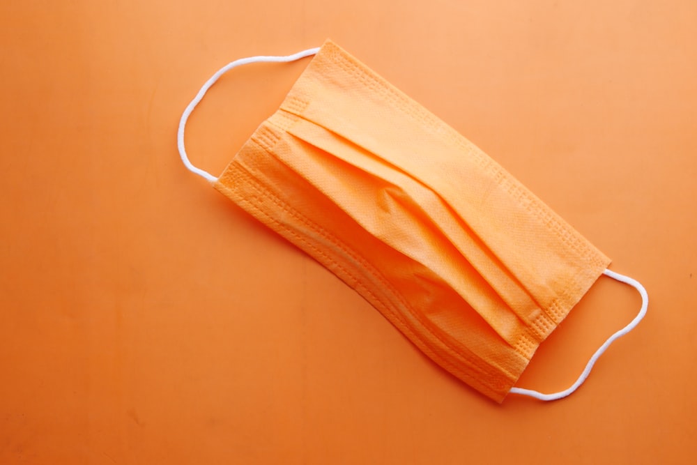 a yellow face mask on an orange background