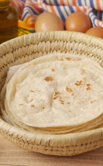 a basket filled with flour next to a bowl of eggs