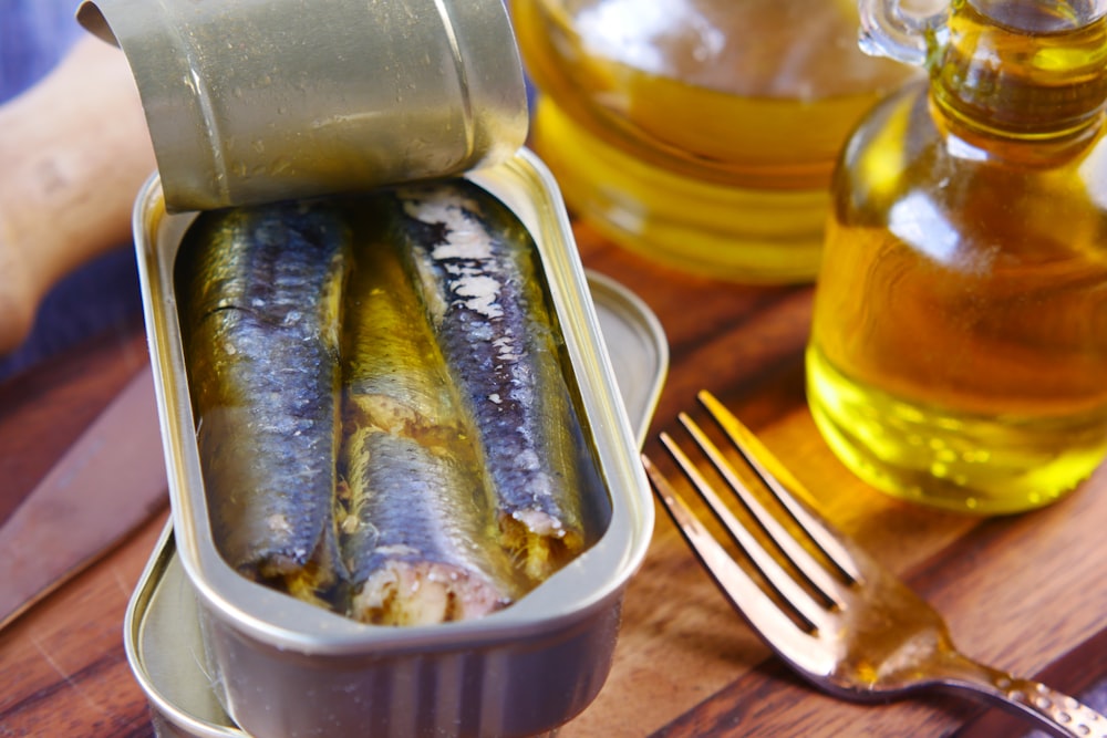 Una lata de sardinas sentada encima de una mesa de madera