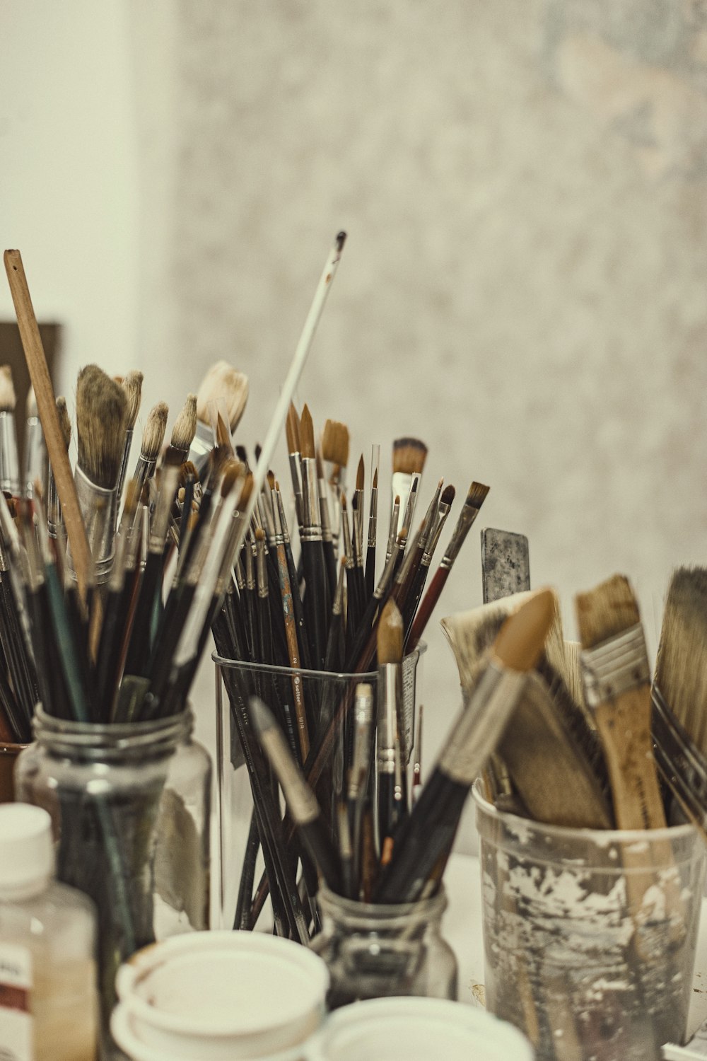 a group of paint brushes sitting in a glass container