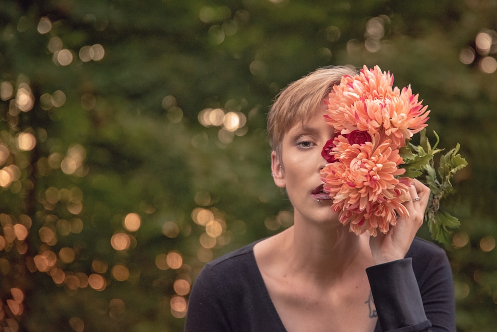 a woman holding a bunch of flowers up to her face