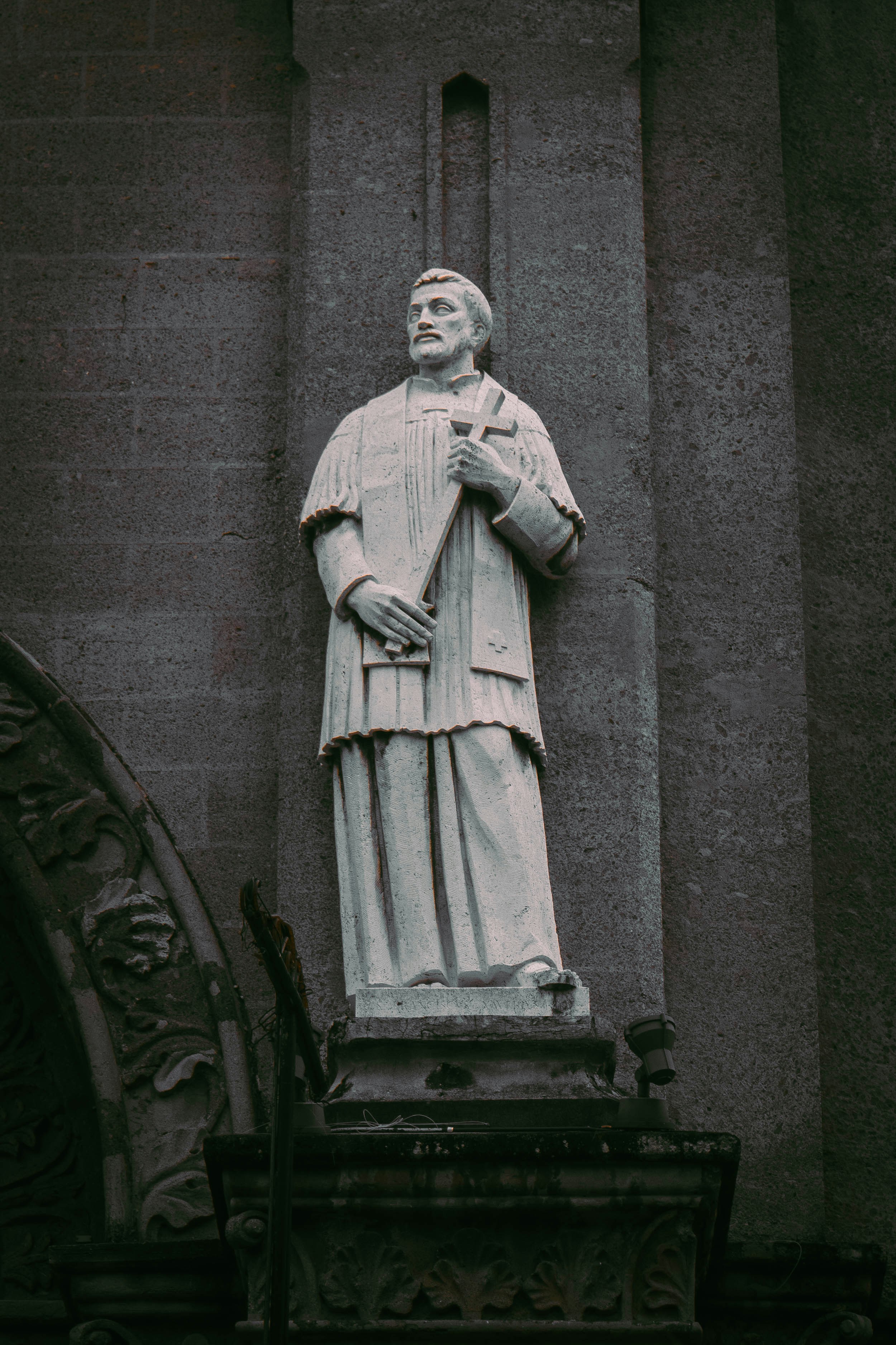 a statue of a man standing next to a building