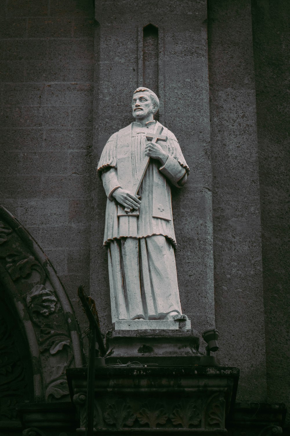 a statue of a man standing next to a building