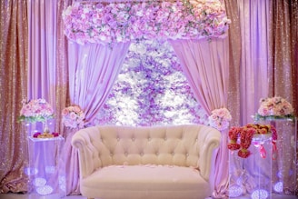 a white couch sitting in front of a window covered in flowers