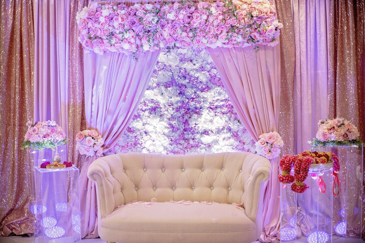 a white couch sitting in front of a window covered in flowers
