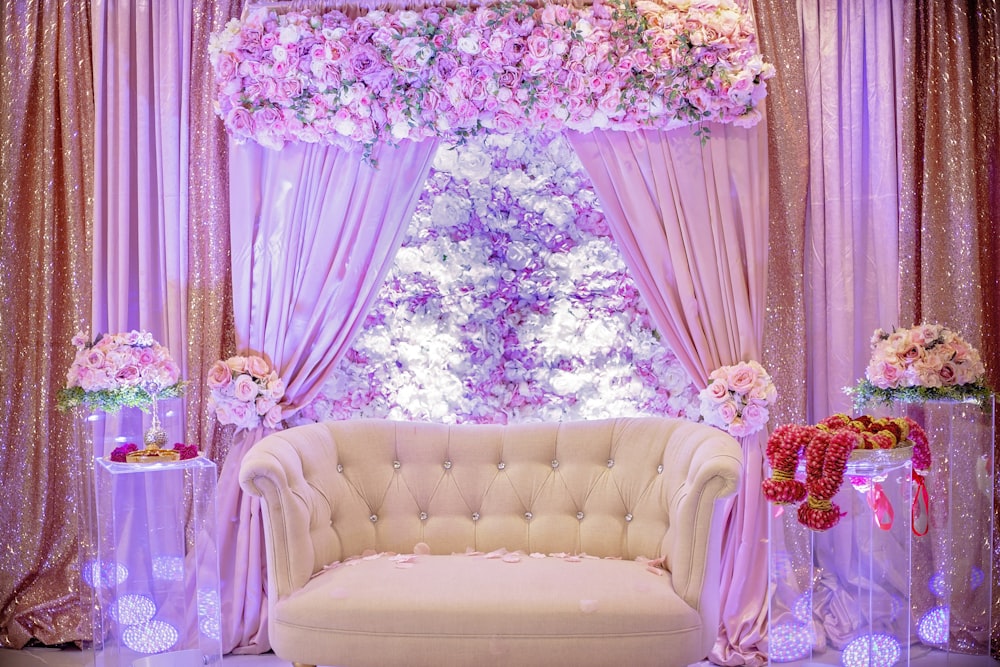a white couch sitting in front of a window covered in flowers