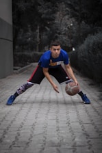 a man in a blue shirt is holding a basketball