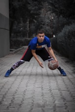 a man in a blue shirt is holding a basketball