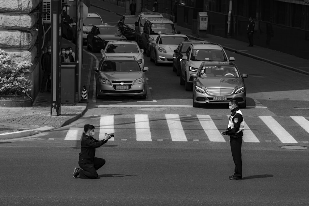 a man kneeling down in the middle of a street