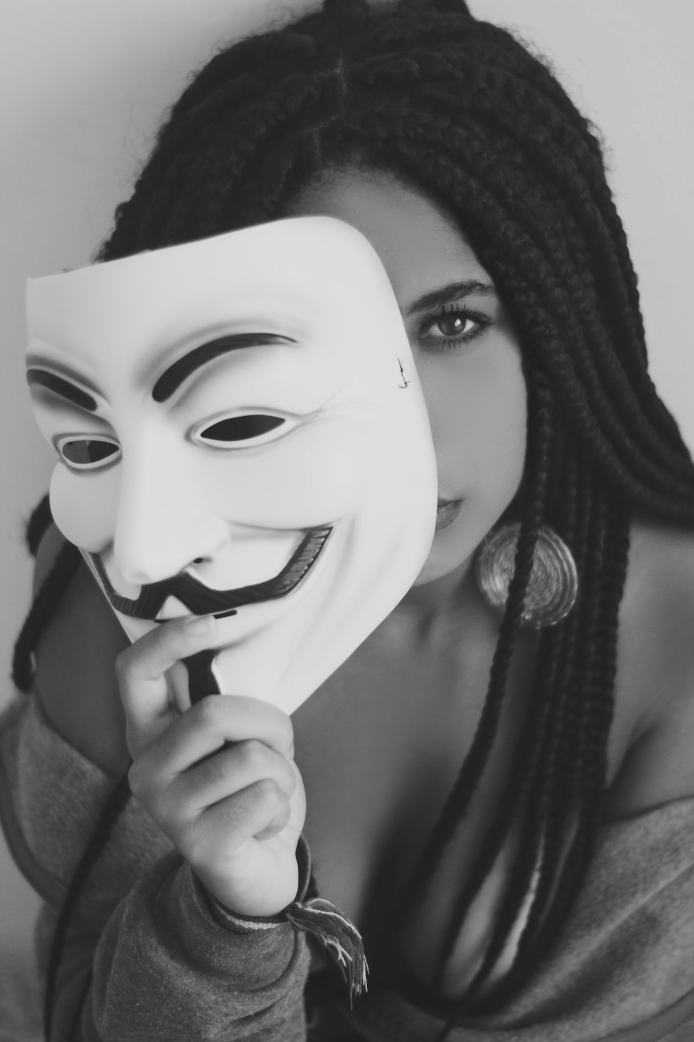Una mujer sosteniendo una máscara en su cara