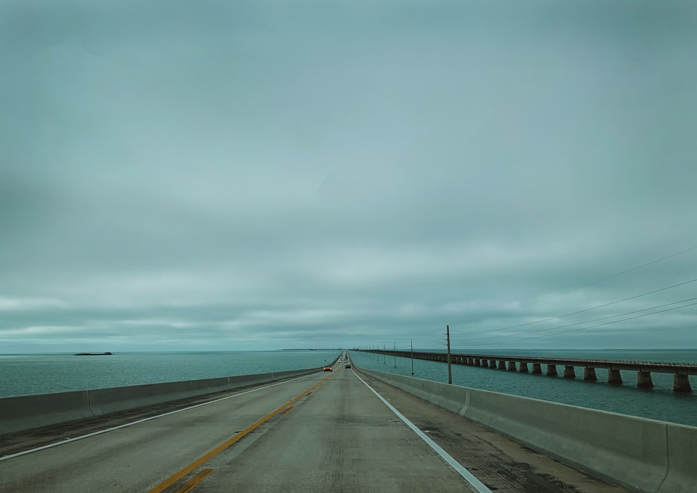 a highway with a bridge and a body of water in the background
