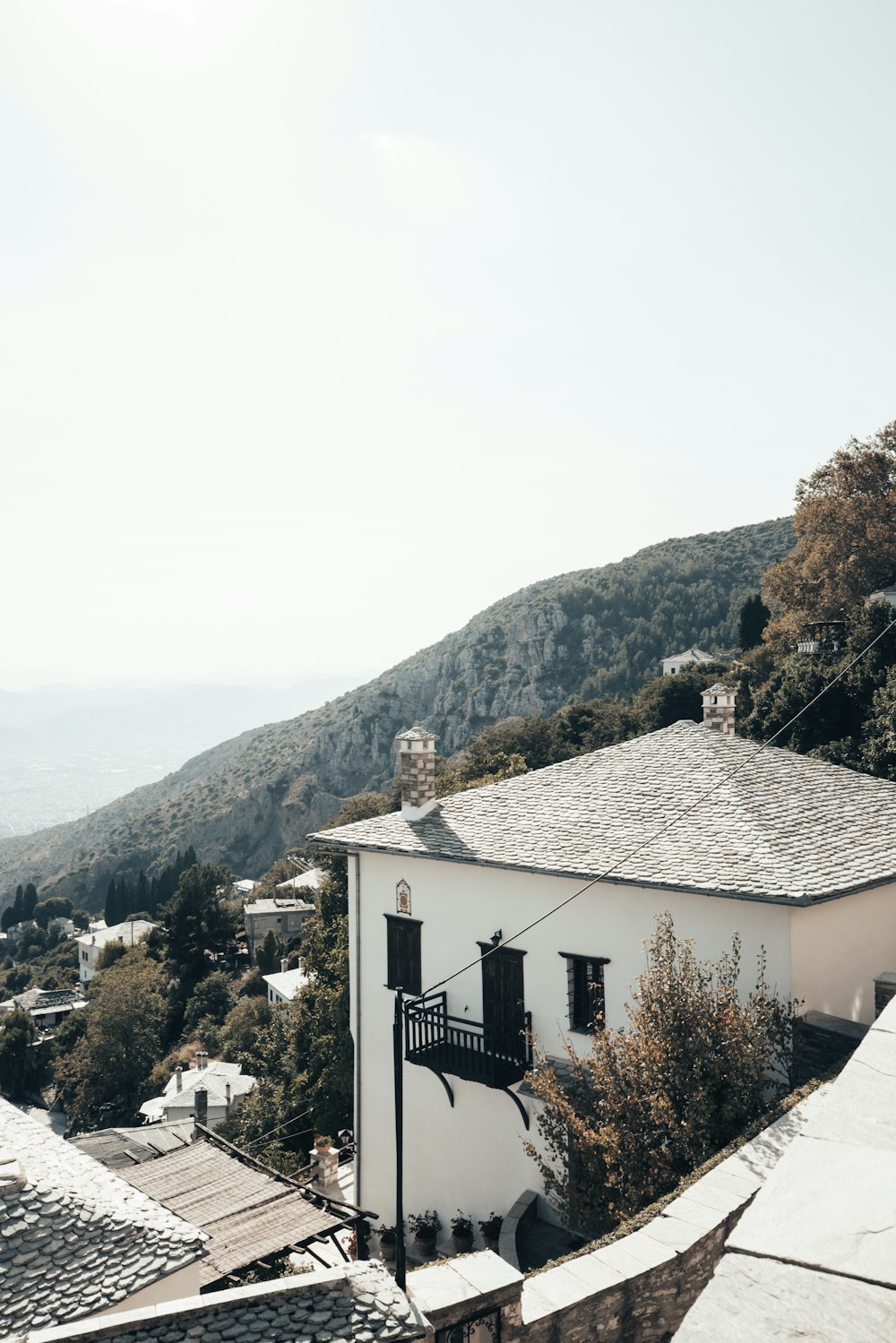 a white building with a balcony on the top of a hill