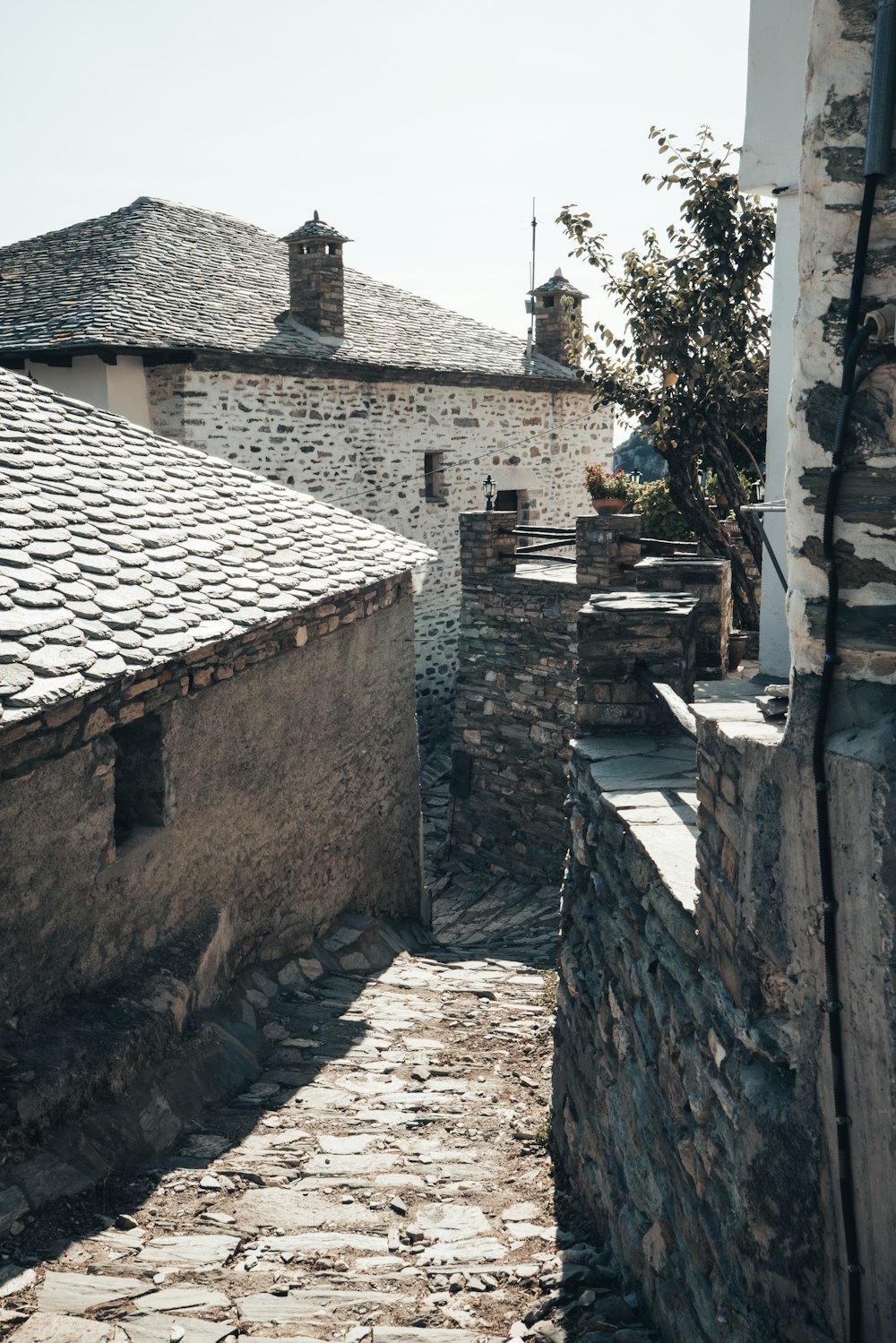 a cobblestone street with a stone building in the background