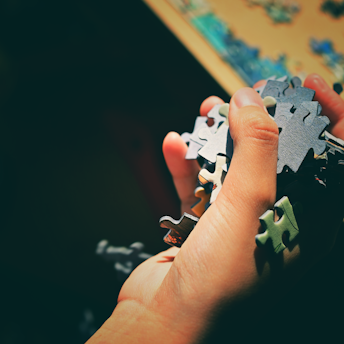 a person holding a puzzle piece in their hand