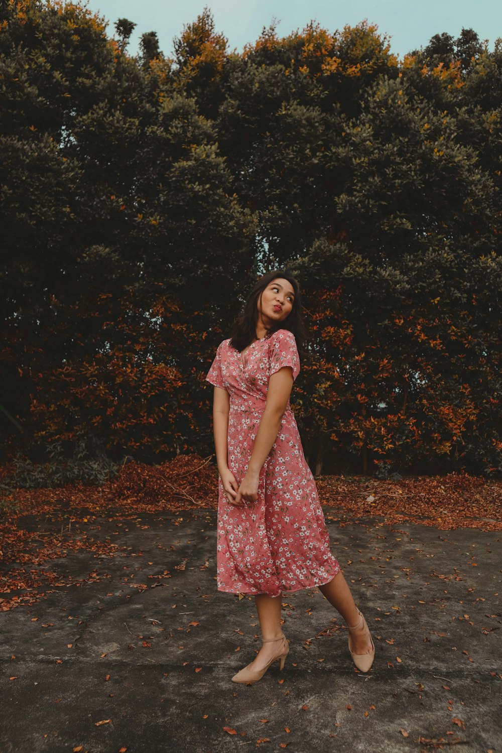 a woman standing in front of some trees