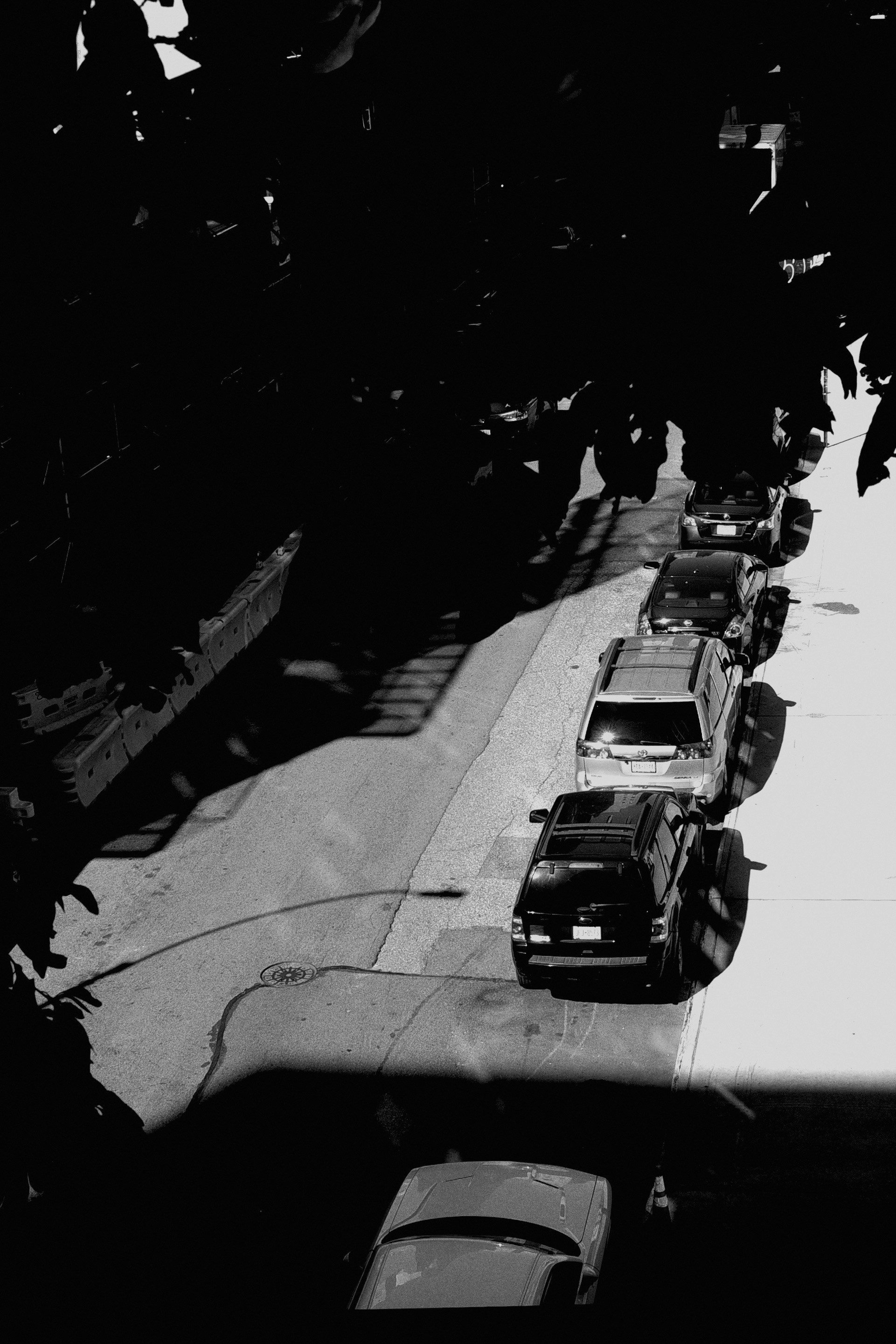 a black and white photo of cars parked on a street