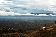 a house on a hill with clouds in the background