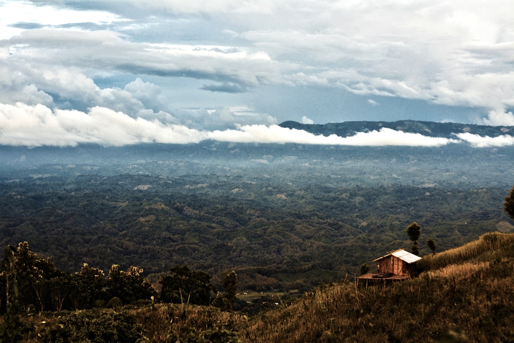 a house on a hill with clouds in the background