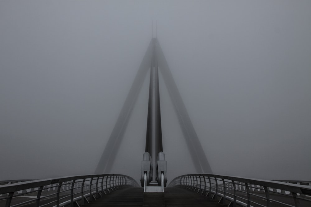 a very tall bridge in the middle of a foggy day