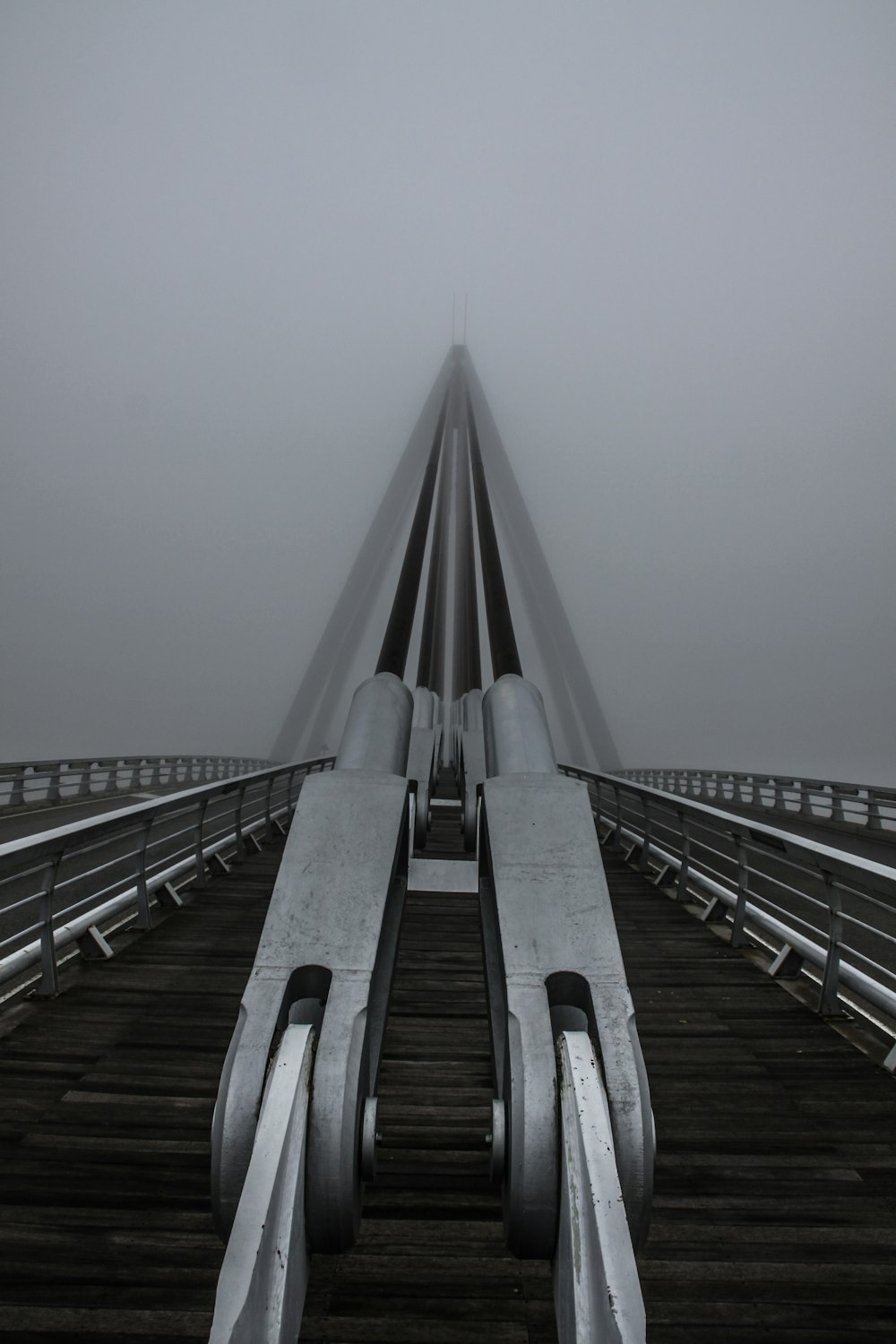 a very long bridge that is in the fog