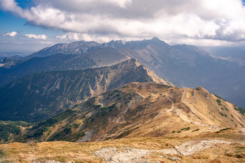 a view of a mountain range from the top of a hill