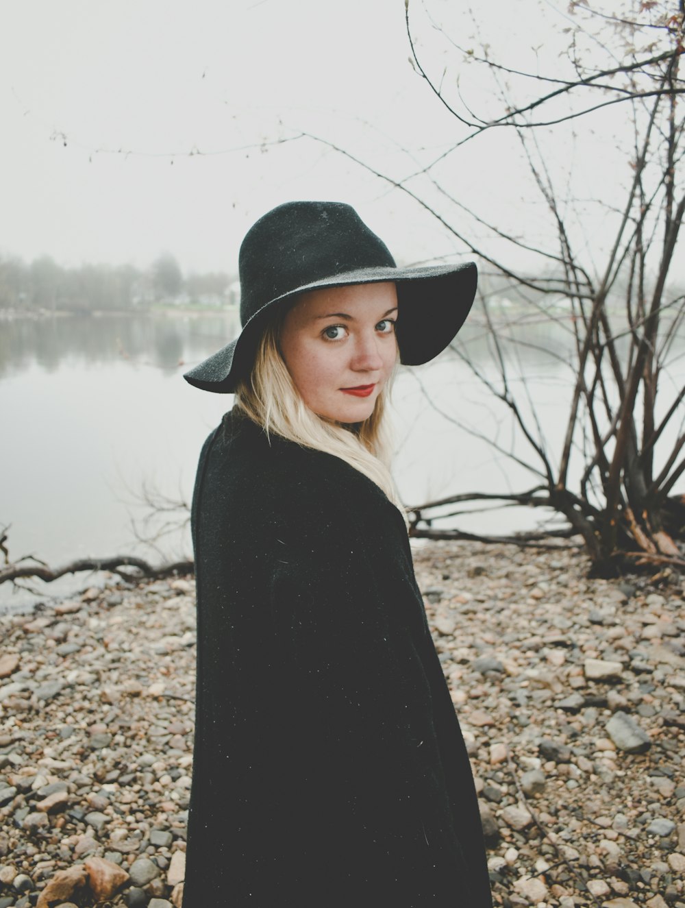 a woman wearing a black hat and a black coat